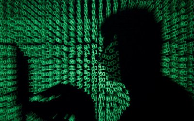 Man holds laptop computer as cyber code is projected on him in this illustration picture