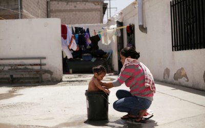 Guatemalan migrant Corio, who is waiting for her court hearing for asylum seekers that returned to Mexico to await their legal proceedings under a new policy established by the U.S. government, baths her daughter at migrant shelter in Ciudad Juarez