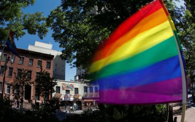 A rainbow flag waves in the wind at the Stonewall National Monument outside the Stonewall Inn in New York