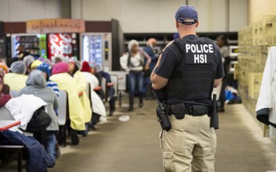 FILE PHOTO: Homeland Security Investigations (HSI) officers from Immigration and Customs Enforcement (ICE) look on after executing search warrants and making some arrests at an agricultural processing facility in Canton