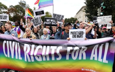 LGBTQ activists and supporters block the street outside the U.S. Supreme Court as it hears arguments in a major LGBT rights case in Washington