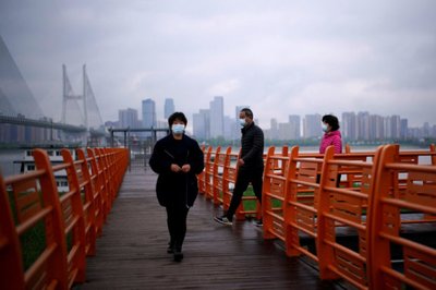 People wearing face masks walk, in Wuhan