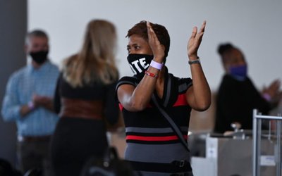 A woman claps hands after a news conference held by Chairman of Fulton County Board of Commissioners Robb Pitts and Fulton County Registration and Elections Director Richard Barron in Atlanta