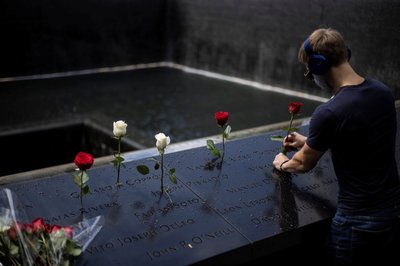 A man places roses at the 9/11 Memorial ahead of the 20th anniversary of the September 11 attacks in Manhattan, New York City, U.S.