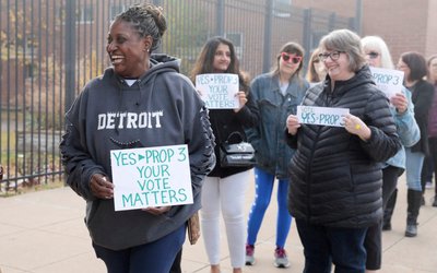 FILE PHOTO: Abortion rights activist Fabian Hill holds a sign while waiting in line to see former U.S. President Barack Obama and Michigan Governor Gretchen Whitmer before mid-term elections in Detroit