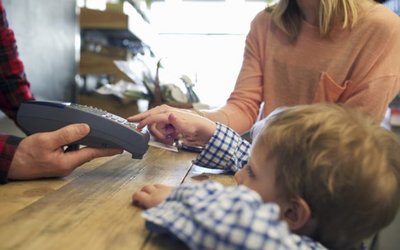 Boy using credit card machine in store