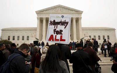 A demonstrator holds a sign aloft as the affirmative action in university admissions case was being heard at the Supreme Court in Washington
