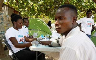 A health worker examines a man during an HIV/AIDS awareness campaign on the occasion of World AIDS Day at the Kuchingoro IDPs camp in Abuja