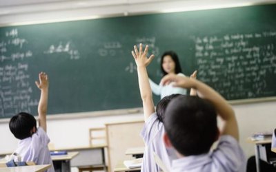 Students in Classroom Raising Hands