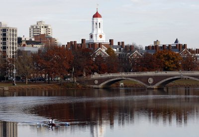 A pair of rowers are seen in the Charles River as Harvard University is reflected in the water in Cambridge