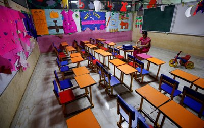 FILE PHOTO: A teacher sits in an empty classroom after Tamil Nadu state government ordered the closure of primary schools across the state amid coronavirus fears, in Chennai