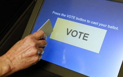 An elections official demonstrates a touch-screen voting machine at the Fairfax County Governmental Center in Fairfax Virginia