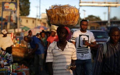 A man selling fried plantain walks along a street in Port-au-Prince
