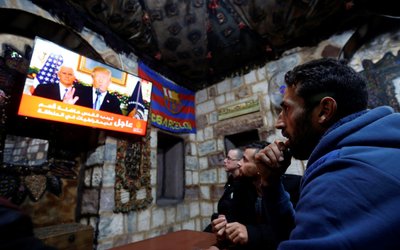 Palestinians watch a televised broadcast of U.S. President Trump delivering an address, in the West Bank city of Nablus