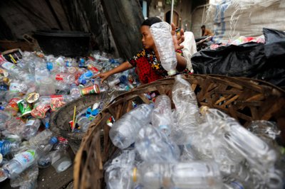 A woman sorts plastic bottles for recycling at Cilincing district in Jakarta