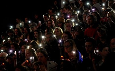 People hold up the phone lights during a moment of silence at a vigil for the victims of the shooting at the Science, Technology, Engineering and Math (STEM) School in Highlands Ranch