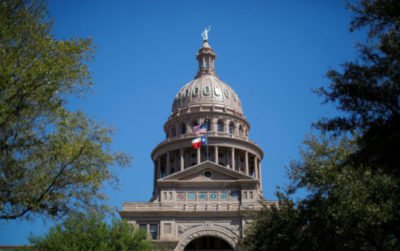 The U.S flag and the Texas State flag fly over the Texas State Capitol as the state senate debates the #SB6 bathroom bill in Austin