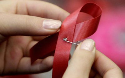 A student makes an AIDS red ribbon during a World AIDS Day event