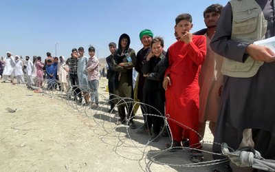 People wait outside Hamid Karzai International Airport in Kabul