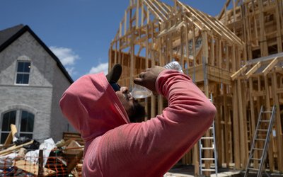 Builder takes water break during hot weather in Manvel, Texas