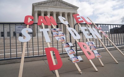 A sign calling for student loan debt relief is seen in front of the Supreme Court