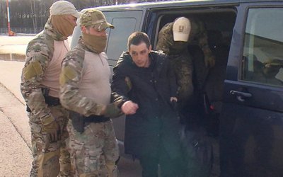 Former U.S. Marine Trevor Reed is escorted to a plane as part of a prisoner swap, in Moscow