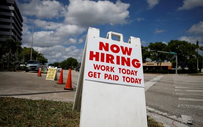 FILE PHOTO: A "Now Hiring" sign advertising jobs at a hand car wash is seen in Miami