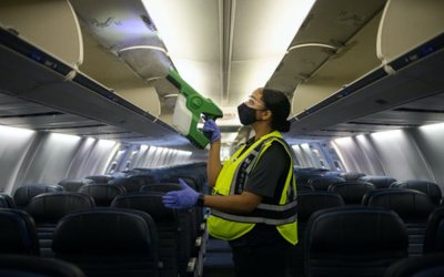 Worker demonstrates use of an electrostatic disinfectant sprayer on United Airlines plane at IAH George Bush Intercontinental Airport in Houston