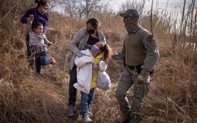 Asylum seeking migrants are escorted out of the brush after crossing Rio Grande river into the U.S. from Mexico in Penitas, Texas