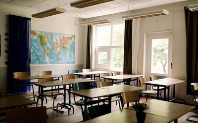 Desks and chairs arranged in classroom at high school