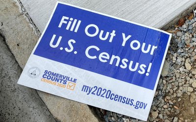 FILE PHOTO: A sign encouraging participation in the U.S. Census lies on a sidewalk in Somerville