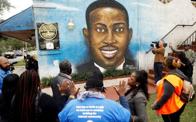 FILE PHOTO: People gather in front of a mural of Ahmaud Arbery in Brunswick