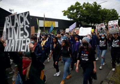 Nathan Hale High School seniors join with others to protest against racial inequality in the aftermath of the death in Minneapolis police custody of George Floyd on their graduation day in Seattle