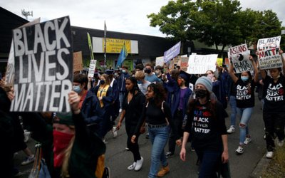 Nathan Hale High School seniors join with others to protest against racial inequality in the aftermath of the death in Minneapolis police custody of George Floyd on their graduation day in Seattle