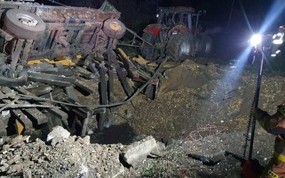 A damaged vehicle lies next to a crater formed at the site of an explosion in Przewodow