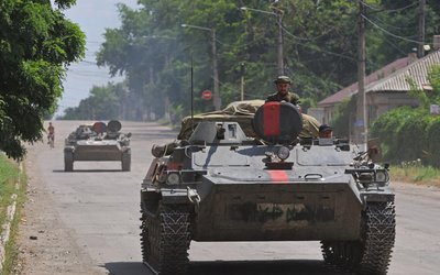 Service members of pro-Russian troops ride an infantry fighting vehicle in Lysychansk