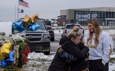 People pay their respects at a memorial at Oxford High School, a day after a shooting that left four dead and eight injured, in Oxford