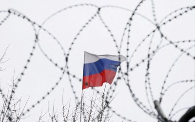 FILE PHOTO: The Russian flag is seen through barbed wire as it flies on the roof of the Russian embassy in Kiev