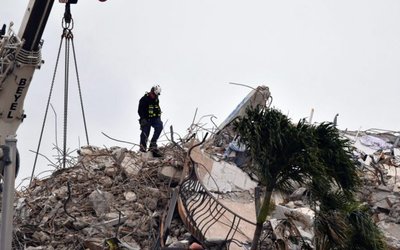 Jul 6, 2021; Surfside, FL, USA; A crew of search and rescue workers on top of what was once Champlain Towers South condominium