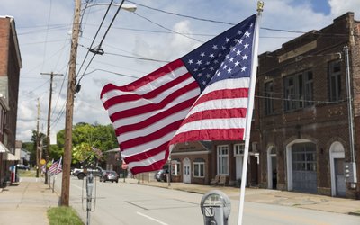 American flag fluttering in the breeze on a deserted main street