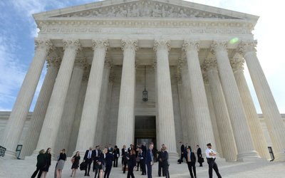 FILE PHOTO: People leave the Supreme Court after it resumed hearing oral arguments at the start of its new term in Washington
