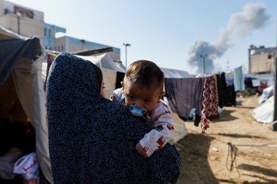 Smoke rises from nearby Israeli strikes as seen from a tent camp sheltering displaced Palestinians, in Khan Younis