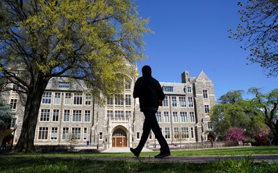 A man walks at an empty campus green at Georgetown University, closed weeks ago due to coronavirus, in Washington