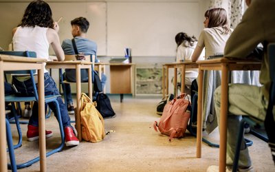 Multiracial group of students sitting at desk in classroom
