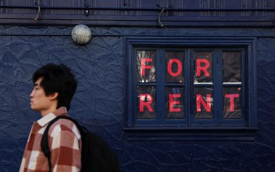 A man walks by as sign advertising real estate for rent in the SoHo area of New York City