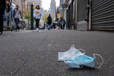 A pair of discarded face masks sit on the side walk in New York City