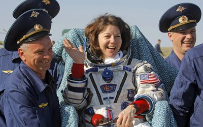 Ground personnel carry NASA astronaut Cady Coleman shortly after landing in the Soyuz TMA-20, southeast of Zhezkazgan