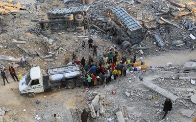 Palestinians fill up containers with water, in Jabalia refugee camp