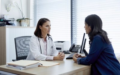 Doctor talking with female patient in clinic