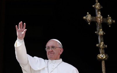 Pope Francis waves during his "Urbi et Orbi" address from a balcony in St. Peter's Square at the Vatican